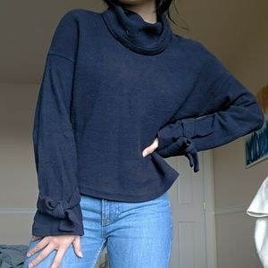 Navy turtleneck sweater with bow tie sleeves